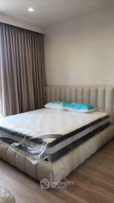 Modern bedroom with elegant bed and floor-to-ceiling curtains in a stylish apartment.