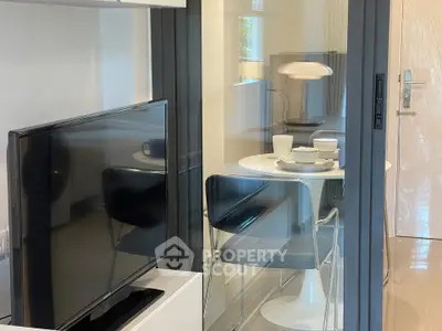 Modern apartment interior with sleek TV setup and stylish dining area.