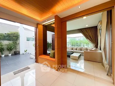 Luxurious living room with open layout and garden view, featuring elegant wooden accents and modern furnishings.
