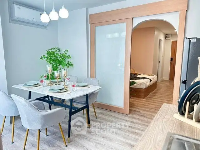 Modern dining area with elegant table setting and view into cozy bedroom