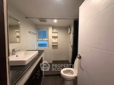 Modern bathroom with sleek fixtures and spacious shower area in a contemporary home.