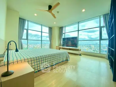 Spacious bedroom with panoramic city views and modern furnishings