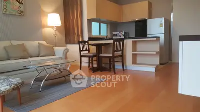 Modern open-layout living room with cozy seating and stylish kitchen area.