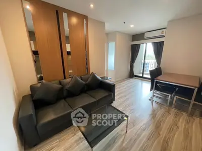 Modern living room with sleek black sofa and balcony view