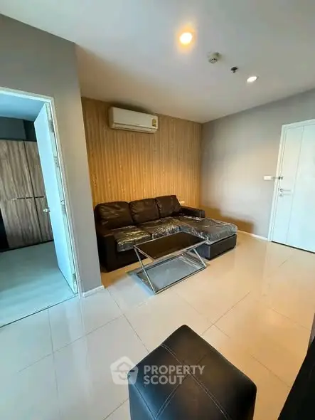 Modern living room with sleek leather sofa and air conditioning in a stylish apartment.