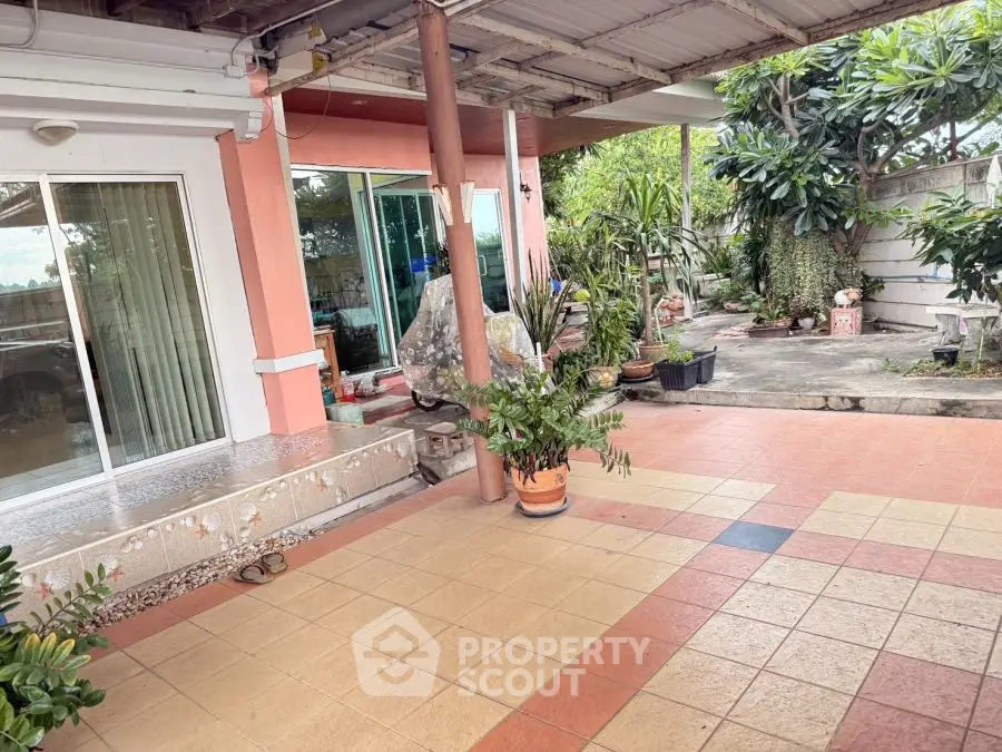 Charming patio with tiled flooring and lush greenery in a cozy residential setting.