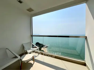 Stunning balcony with panoramic ocean view and modern seating area.