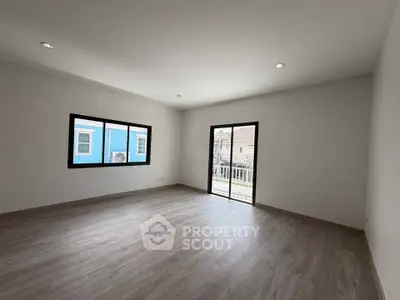 Spacious empty room with large windows and balcony access, perfect for customization.