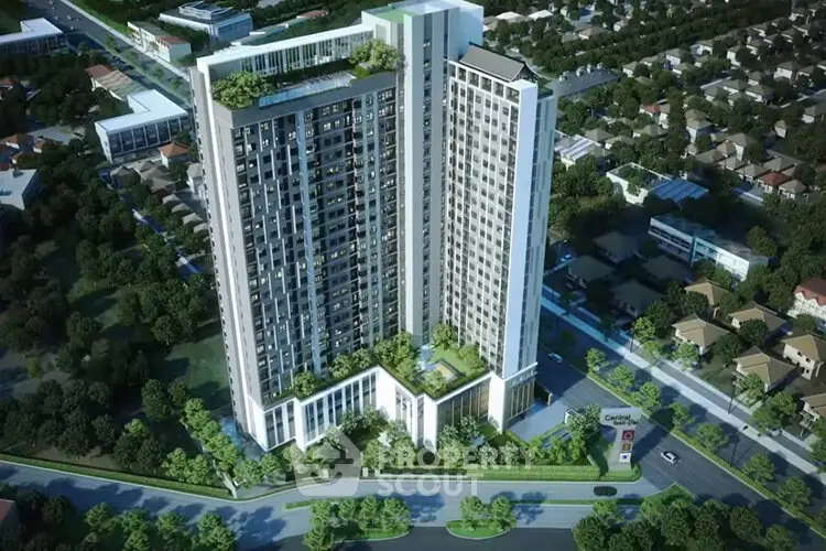 Stunning aerial view of modern high-rise building with lush greenery and urban surroundings.