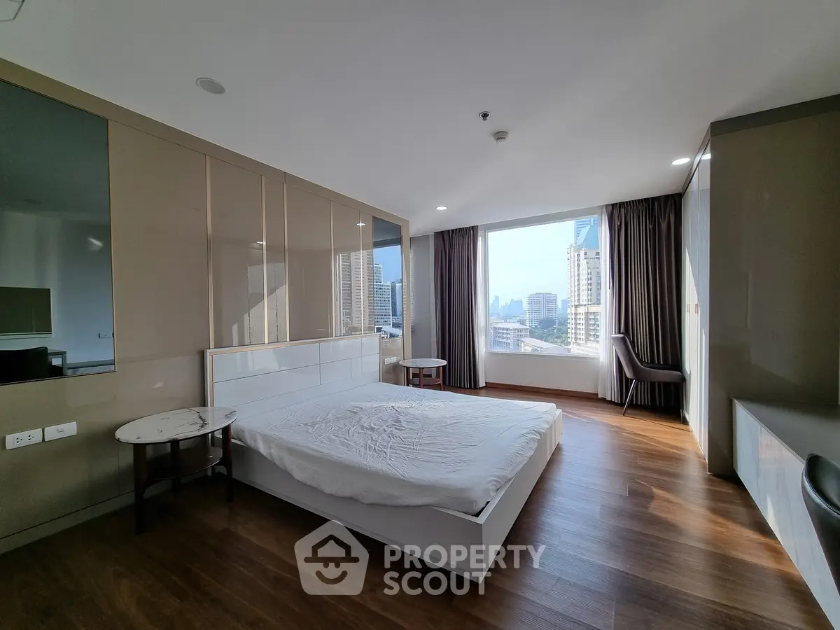 Spacious modern bedroom with city view and wooden flooring