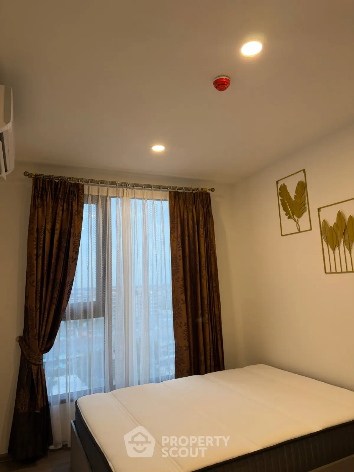 Cozy bedroom with elegant curtains and modern decor in a high-rise apartment.
