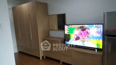 Modern living room with wooden furniture and flat-screen TV in a stylish apartment.