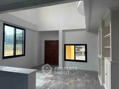 Spacious modern living room with large windows and high ceiling