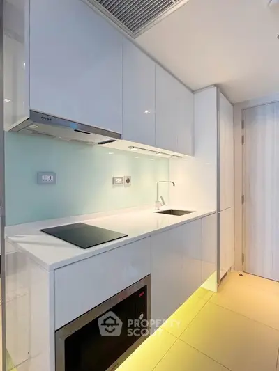 Modern kitchen with sleek white cabinetry and built-in appliances