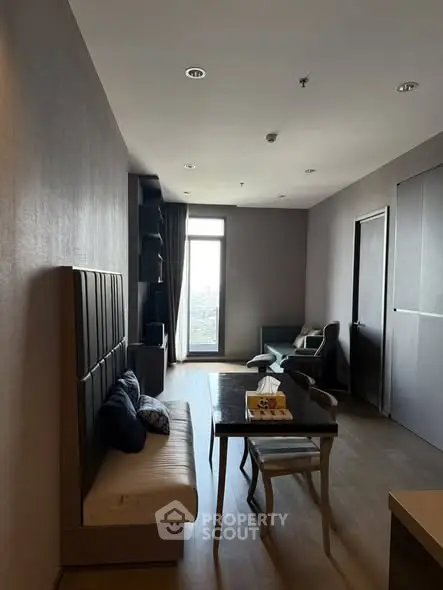 Modern living room with sleek furniture and large window offering city view