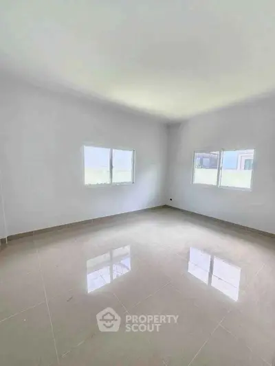 Spacious empty room with large windows and glossy tiled floor, perfect for customization.