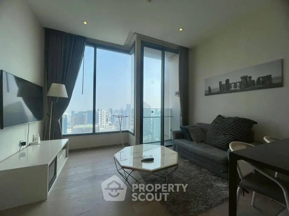 Modern living room with large windows offering stunning city views, stylish furniture, and elegant decor.