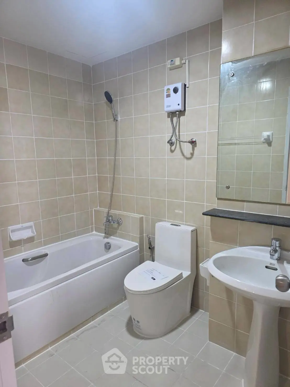 Modern bathroom with bathtub, shower, and sleek fixtures in a tiled setting.