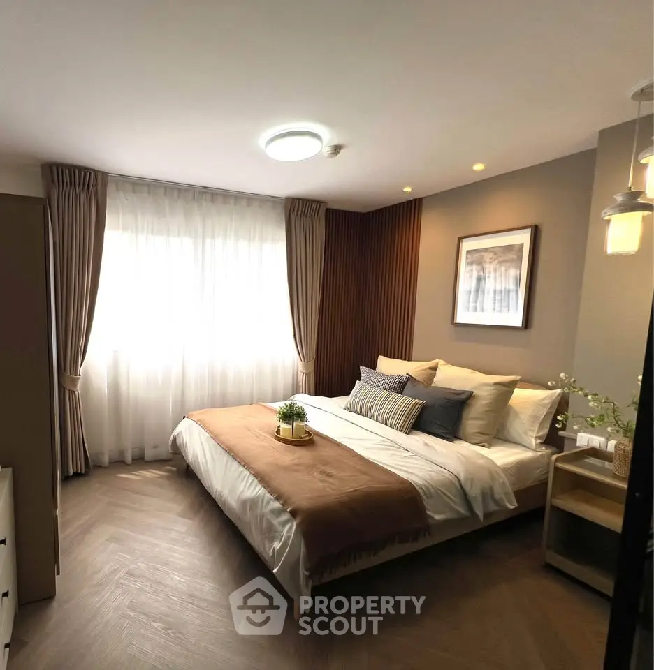 Elegant bedroom with cozy decor and natural light, featuring stylish curtains and modern lighting.