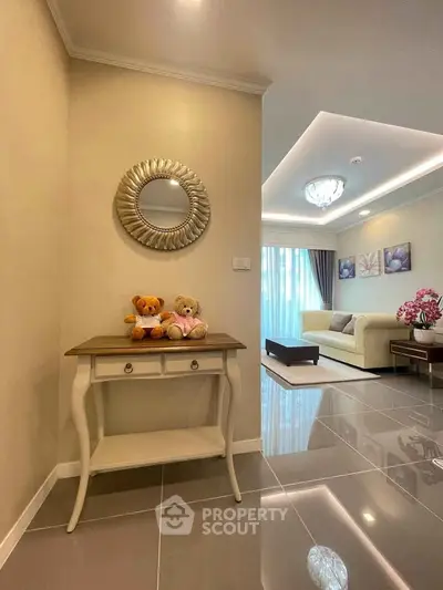Elegant living room with modern decor and plush seating, featuring a stylish console table and decorative mirror.