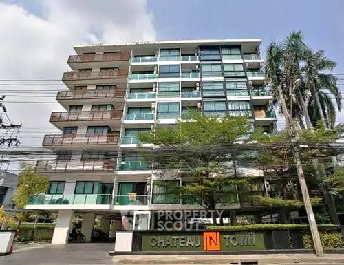 Modern multi-story residential building with balconies and lush greenery.