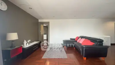 Spacious living room with modern black leather sofa and stylish decor