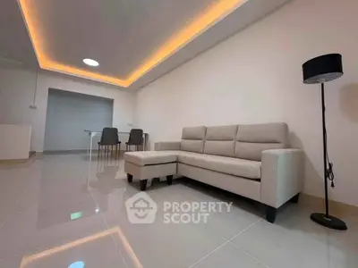Modern living room with sleek sofa and ambient lighting, perfect for relaxation and entertaining.