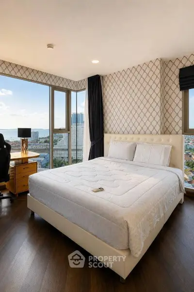 Luxurious bedroom with stunning city view and elegant decor, featuring a comfortable bed and stylish workspace.