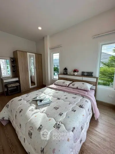 Cozy bedroom with stylish decor and ample natural light, featuring a comfortable bed and modern wardrobe.