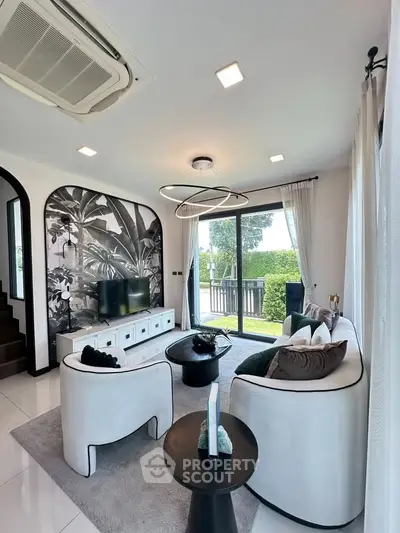 Stylish living room with modern decor and large windows offering garden views.