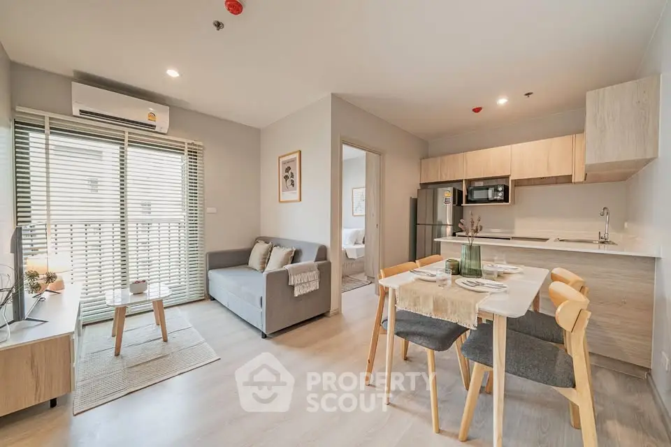 Modern open-plan living room and kitchen with stylish decor and natural light.