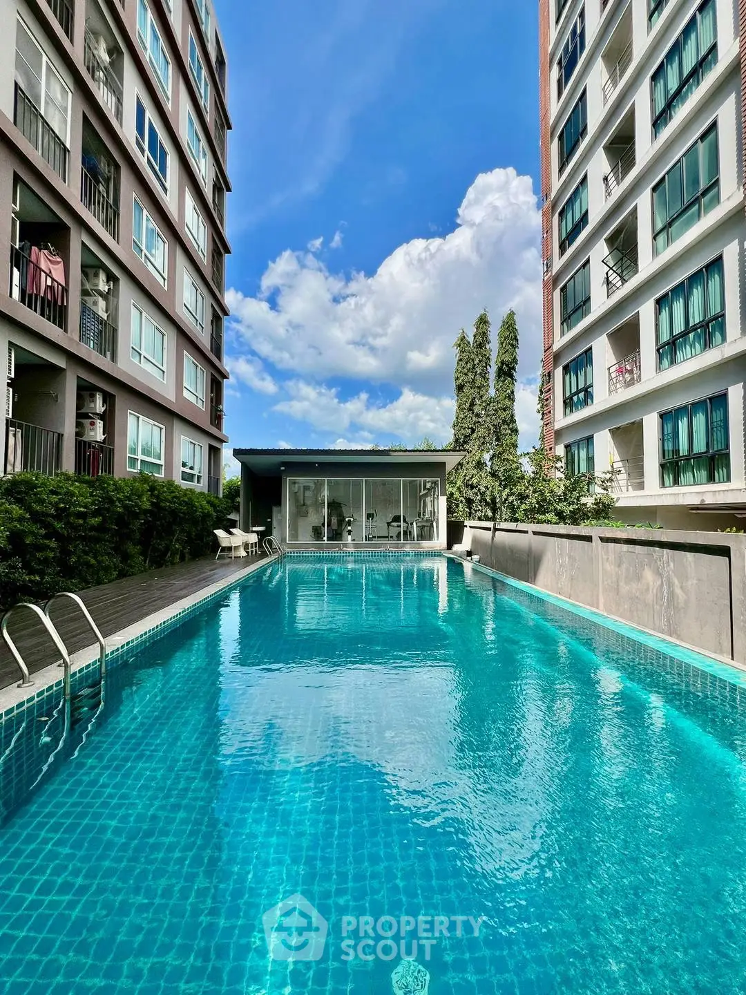 Luxurious residential pool area with modern buildings and clear blue sky