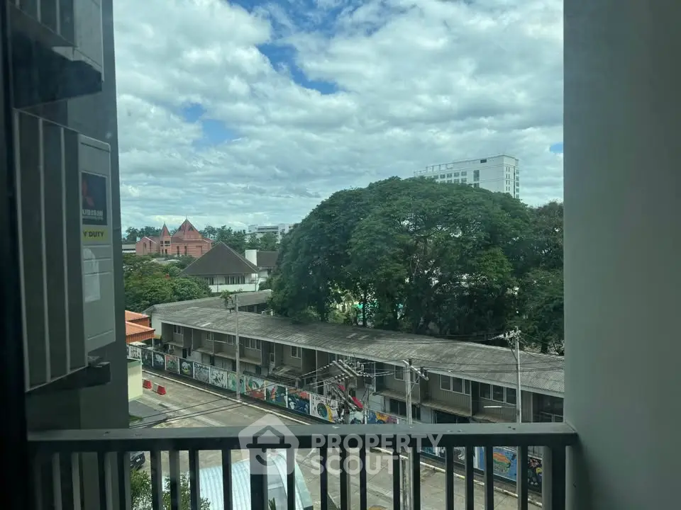 Scenic urban view from balcony with lush greenery and cityscape