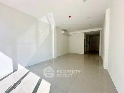 Spacious sunlit room with tiled flooring and air conditioning, perfect for versatile use.