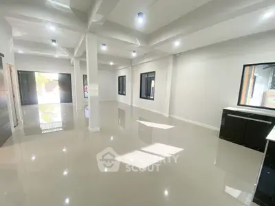 Spacious modern living room with glossy floors and large windows, perfect for natural light.