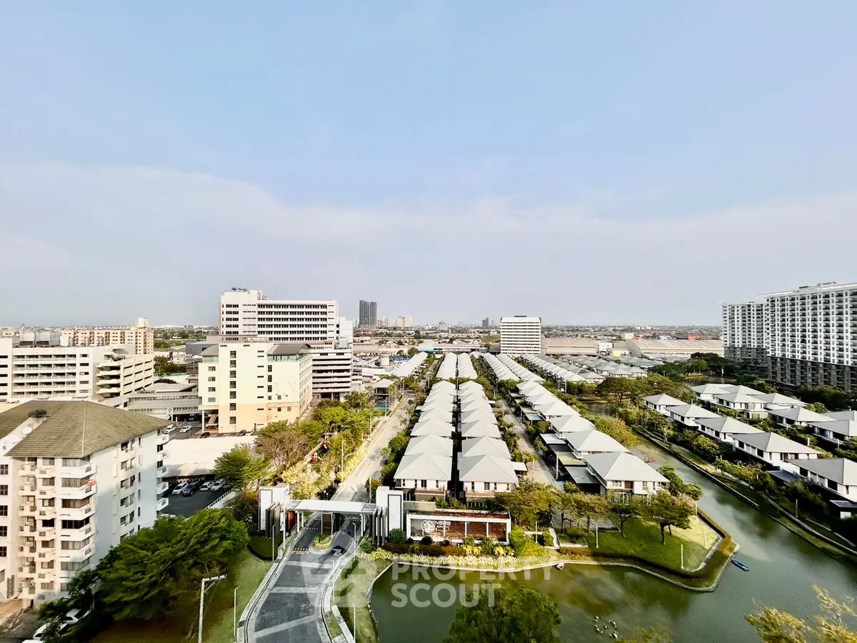 Stunning aerial view of modern residential complex with lush greenery and water features, perfect for serene living.