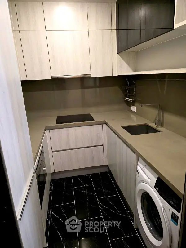 Modern compact kitchen with sleek cabinetry and built-in appliances
