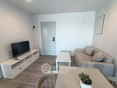 Modern living room with minimalist decor, featuring a cozy sofa, TV, and stylish artwork.