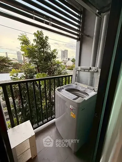 Charming balcony with washing machine and city view, perfect for urban living convenience.