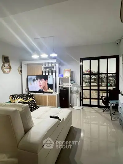 Modern living room with sleek furniture and large TV, perfect for relaxation.