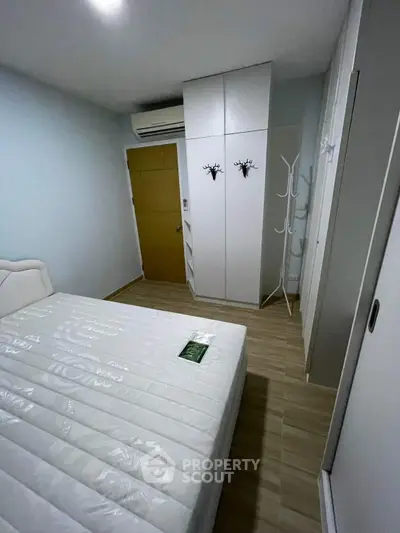Cozy bedroom with minimalist design, featuring a comfortable bed and ample storage space.