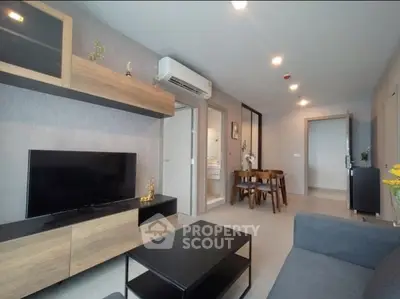 Modern living room with stylish furniture and open dining area in a contemporary apartment.
