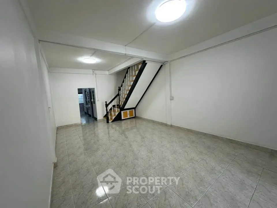 Spacious tiled living area with staircase, ideal for modern family living.
