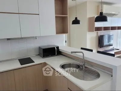 Modern kitchen with sleek design and open layout, featuring built-in appliances and stylish lighting.