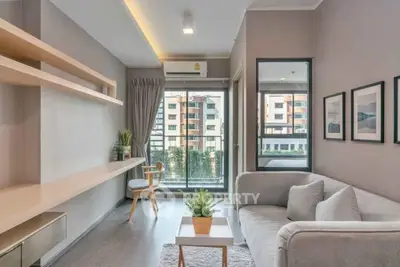 Modern living room with stylish decor and large window offering city view