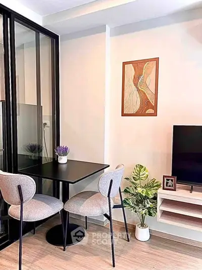 Modern living room with stylish decor, featuring a cozy dining area and sleek TV setup.
