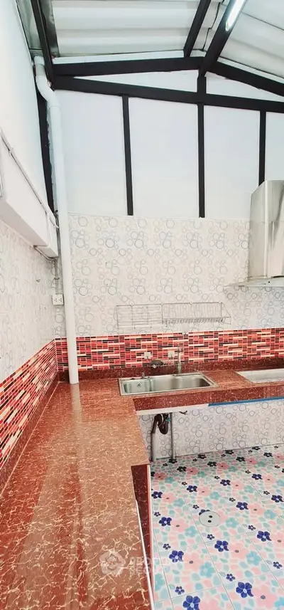 Modern kitchen with red marble countertops and patterned tile flooring