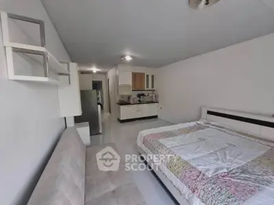 Spacious studio apartment with modern kitchen and cozy bed area, ideal for urban living.