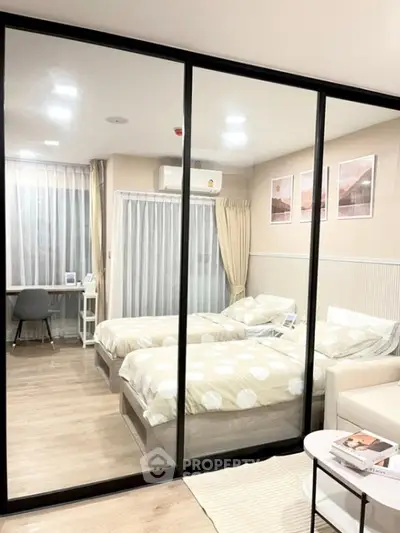 Modern bedroom with twin beds, glass partition, and cozy decor in a stylish apartment.
