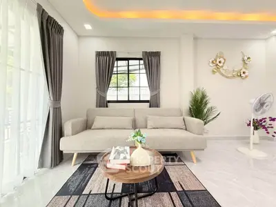 Modern living room with stylish sofa, elegant decor, and large windows for natural light.